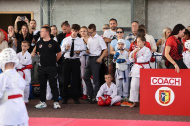 ODESSA, UKRAINE - 21 Eylül 2024: Çocuk ve gençlik sporları. Ukrayna Karate Kupası. Seyircilerin ebeveynleri destek grubuna koçluk yapıyor, sporcuları duygusal olarak destekliyor. Tribünlerdeki hayranlar karate