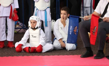 ODESSA, UKRAINE - 21 Eylül 2024: Çocuk ve gençlik sporları. Ukrayna Karate Kupası. Seyircilerin ebeveynleri destek grubuna koçluk yapıyor, sporcuları duygusal olarak destekliyor. Tribünlerdeki hayranlar karate