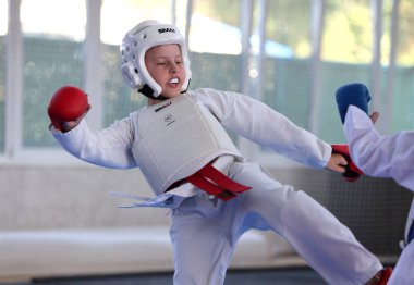 ODESSA, UKRAINE - 21 Eylül 2024: Çocuk ve gençlik sporları. Çocuklar ve kızlar tatami çocuk sporlarında karate dövüşü yapar. Sağlıklı bir yaşam tarzı. Karate sporu yapan çocuklar. Karatekalarla savaş