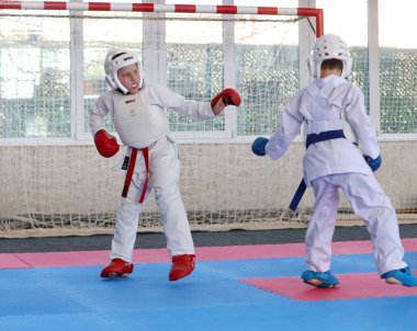 ODESSA, UKRAINE - 21 Eylül 2024: Çocuk ve gençlik sporları. Çocuklar ve kızlar tatami çocuk sporlarında karate dövüşü yapar. Sağlıklı bir yaşam tarzı. Karate sporu yapan çocuklar. Karatekalarla savaş