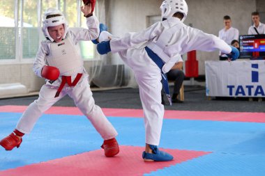 ODESSA, UKRAINE - 21 Eylül 2024: Çocuk ve gençlik sporları. Çocuklar ve kızlar tatami çocuk sporlarında karate dövüşü yapar. Sağlıklı bir yaşam tarzı. Karate sporu yapan çocuklar. Karatekalarla savaş