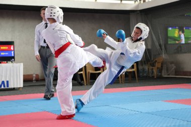 ODESSA, UKRAINE - 21 Eylül 2024: Çocuk ve gençlik sporları. Çocuklar ve kızlar tatami çocuk sporlarında karate dövüşü yapar. Sağlıklı bir yaşam tarzı. Karate sporu yapan çocuklar. Karatekalarla savaş