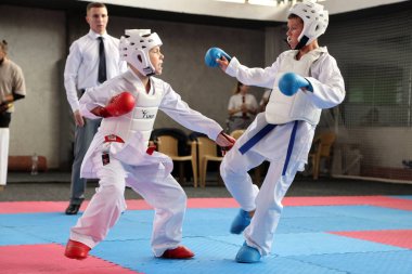 ODESSA, UKRAINE - 21 Eylül 2024: Çocuk ve gençlik sporları. Çocuklar ve kızlar tatami çocuk sporlarında karate dövüşü yapar. Sağlıklı bir yaşam tarzı. Karate sporu yapan çocuklar. Karatekalarla savaş