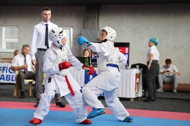 ODESSA, UKRAINE - 21 Eylül 2024: Çocuk ve gençlik sporları. Çocuklar ve kızlar tatami çocuk sporlarında karate dövüşü yapar. Sağlıklı bir yaşam tarzı. Karate sporu yapan çocuklar. Karatekalarla savaş