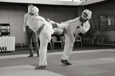 ODESSA, UKRAINE - 21 Eylül 2024: Çocuk ve gençlik sporları. Çocuklar ve kızlar tatami çocuk sporlarında karate dövüşü yapar. Sağlıklı bir yaşam tarzı. Karate sporu yapan çocuklar. Karatekalarla savaş