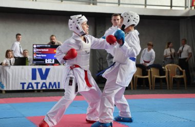 ODESSA, UKRAINE - 21 Eylül 2024: Çocuk ve gençlik sporları. Çocuklar ve kızlar tatami çocuk sporlarında karate dövüşü yapar. Sağlıklı bir yaşam tarzı. Karate sporu yapan çocuklar. Karatekalarla savaş