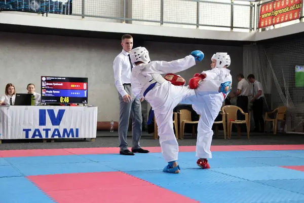 ODESSA, UKRAINE - 21 Eylül 2024: Çocuk ve gençlik sporları. Çocuklar ve kızlar tatami çocuk sporlarında karate dövüşü yapar. Sağlıklı bir yaşam tarzı. Karate sporu yapan çocuklar. Karatekalarla savaş