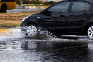 ODESSA, UKRAINE-5 Eylül 2024: Şiddetli yağmurlar, yollarda oluşan trafik sıkışıklıkları sonrasında, arabalar suyla ve duraklamayla dolup taşıyor. Arabalar yollardaki su birikintilerinde yüzer, su sıçratır. Şiddetli yağmurdan sonra yol çöktü