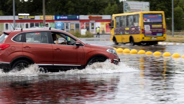 ODESSA, UKRAINE-5 Eylül 2024: Şiddetli yağmurlar, yollarda oluşan trafik sıkışıklıkları sonrasında, arabalar suyla ve duraklamayla dolup taşıyor. Arabalar yollardaki su birikintilerinde yüzer, su sıçratır. Şiddetli yağmurdan sonra yol çöktü