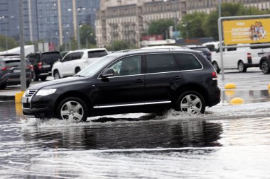 ODESSA, UKRAINE-5 Eylül 2024: Şiddetli yağmurlar, yollarda oluşan trafik sıkışıklıkları sonrasında, arabalar suyla ve duraklamayla dolup taşıyor. Arabalar yollardaki su birikintilerinde yüzer, su sıçratır. Şiddetli yağmurdan sonra yol çöktü