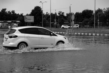 ODESSA, UKRAINE-5 Eylül 2024: Şiddetli yağmurlar, yollarda oluşan trafik sıkışıklıkları sonrasında, arabalar suyla ve duraklamayla dolup taşıyor. Arabalar yollardaki su birikintilerinde yüzer, su sıçratır. Şiddetli yağmurdan sonra yol çöktü