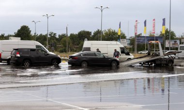 ODESSA, UKRAINE-5 Eylül 2024: Şiddetli yağmurlar, yollarda oluşan trafik sıkışıklıkları sonrasında, arabalar suyla ve duraklamayla dolup taşıyor. Arabalar yollardaki su birikintilerinde yüzer, su sıçratır. Şiddetli yağmurdan sonra yol çöktü