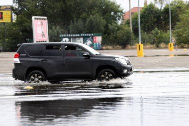 ODESSA, UKRAINE-5 Eylül 2024: Şiddetli yağmurlar, yollarda oluşan trafik sıkışıklıkları sonrasında, arabalar suyla ve duraklamayla dolup taşıyor. Arabalar yollardaki su birikintilerinde yüzer, su sıçratır. Şiddetli yağmurdan sonra yol çöktü