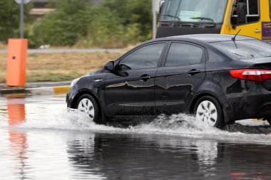 Şiddetli yağmurlardan sonra, yollarda trafik sıkışıklığı oluştu, arabalar suyla kaplandı ve tıkandı. Arabalar yollardaki su birikintilerinde yüzer, su sıçratır. Şiddetli yağmurdan sonra yol çöktü