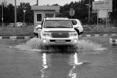 ODESSA, UKRAINE-5 Eylül 2024: Şiddetli yağmurlar, yollarda oluşan trafik sıkışıklıkları sonrasında, arabalar suyla ve duraklamayla dolup taşıyor. Arabalar yollardaki su birikintilerinde yüzer, su sıçratır. Şiddetli yağmurdan sonra yol çöktü