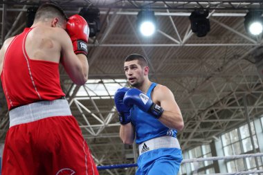 ODESSA, UKRAINE - 10 Mart 2025 Ukrayna Boks Kupası. Son dövüş ağırlığı 80 kg, Red Matvii Razhba, Blue-Illiusha Pavel. Ringde kanlı bir kavga. Erkekler şampiyonlar için ringde boks yapar.