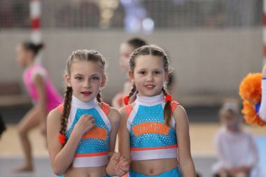ODESSA, UKRAINE - 30 Nisan 2025: Çocuk Amigoluğu Şampiyonası. Genç ponpon kızlar spor salonundaki şehir ponpon kız şampiyonasında gösteri yapıyorlar. Çocuk sporları, sağlıklı yaşam tarzı. Seyirciler, duygular