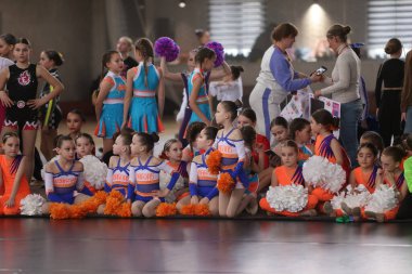 ODESSA, UKRAINE - 30 Nisan 2025: Çocuk Amigoluğu Şampiyonası. Genç ponpon kızlar spor salonundaki şehir ponpon kız şampiyonasında gösteri yapıyorlar. Çocuk sporları, sağlıklı yaşam tarzı. Seyirciler, duygular