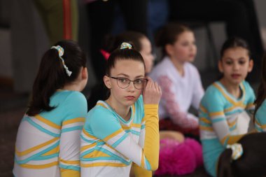 ODESSA, UKRAINE - 30 Nisan 2025: Çocuk Amigoluğu Şampiyonası. Genç ponpon kızlar spor salonundaki şehir ponpon kız şampiyonasında gösteri yapıyorlar. Çocuk sporları, sağlıklı yaşam tarzı. Seyirciler, duygular