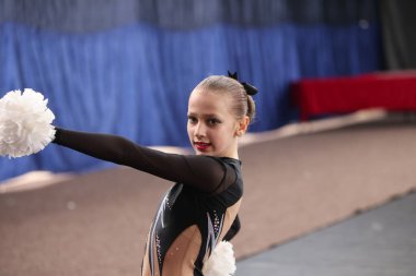 ODESSA, UKRAINE - 30 Nisan 2025: Çocuk Amigoluğu Şampiyonası. Genç ponpon kızlar spor salonundaki şehir ponpon kız şampiyonasında gösteri yapıyorlar. Çocuk sporları, sağlıklı yaşam tarzı. Seyirciler, duygular