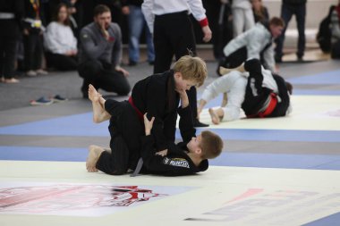 ODESSA, UKRAINE - 6 Nisan 2025: Ukrayna ulusal yarışmacı jiu jitsu genç sporcuları yoğun dövüşler düzenliyor, şampiyonluk için tatamiyle mücadele ediyorlar