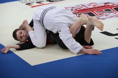 ODESSA, UKRAINE - 6 Nisan 2025: Ukrayna ulusal yarışmacı jiu jitsu genç sporcuları yoğun dövüşler düzenliyor, şampiyonluk için tatamiyle mücadele ediyorlar
