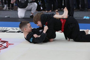 ODESSA, UKRAINE - 6 Nisan 2025: Ukrayna ulusal yarışmacı jiu jitsu genç sporcuları yoğun dövüşler düzenliyor, şampiyonluk için tatamiyle mücadele ediyorlar
