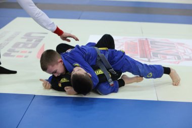 ODESSA, UKRAINE - 6 Nisan 2025: Ukrayna ulusal yarışmacı jiu jitsu genç sporcuları yoğun dövüşler düzenliyor, şampiyonluk için tatamiyle mücadele ediyorlar