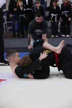 ODESSA, UKRAINE - 6 Nisan 2025: Ukrayna ulusal yarışmacı jiu jitsu genç sporcuları yoğun dövüşler düzenliyor, şampiyonluk için tatamiyle mücadele ediyorlar
