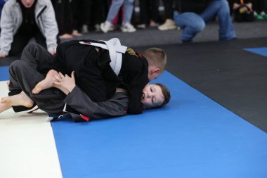 ODESSA, UKRAINE - 6 Nisan 2025: Ukrayna ulusal yarışmacı jiu jitsu genç sporcuları yoğun dövüşler düzenliyor, şampiyonluk için tatamiyle mücadele ediyorlar
