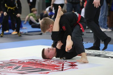 ODESSA, UKRAINE - 6 Nisan 2025: Ukrayna ulusal yarışmacı jiu jitsu genç sporcuları yoğun dövüşler düzenliyor, şampiyonluk için tatamiyle mücadele ediyorlar