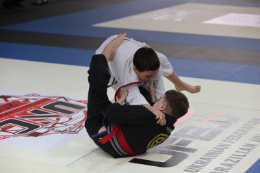 ODESSA, UKRAINE - 6 Nisan 2025: Ukrayna ulusal yarışmacı jiu jitsu genç sporcuları yoğun dövüşler düzenliyor, şampiyonluk için tatamiyle mücadele ediyorlar