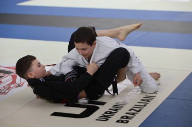 ODESSA, UKRAINE - 6 Nisan 2025: Ukrayna ulusal yarışmacı jiu jitsu genç sporcuları yoğun dövüşler düzenliyor, şampiyonluk için tatamiyle mücadele ediyorlar