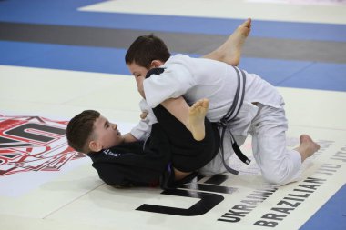ODESSA, UKRAINE - 6 Nisan 2025: Ukrayna ulusal yarışmacı jiu jitsu genç sporcuları yoğun dövüşler düzenliyor, şampiyonluk için tatamiyle mücadele ediyorlar