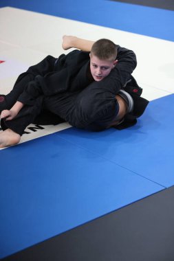 ODESSA, UKRAINE - 6 Nisan 2025: Ukrayna ulusal yarışmacı jiu jitsu genç sporcuları yoğun dövüşler düzenliyor, şampiyonluk için tatamiyle mücadele ediyorlar