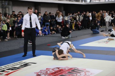 ODESSA, UKRAINE - 6 Nisan 2025: Ukrayna ulusal yarışmacı jiu jitsu genç sporcuları yoğun dövüşler düzenliyor, şampiyonluk için tatamiyle mücadele ediyorlar
