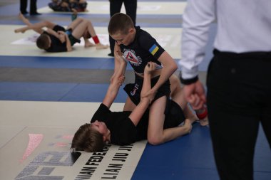 ODESSA, UKRAINE - 6 Nisan 2025: Ukrayna ulusal yarışmacı jiu jitsu genç sporcuları yoğun dövüşler düzenliyor, şampiyonluk için tatamiyle mücadele ediyorlar