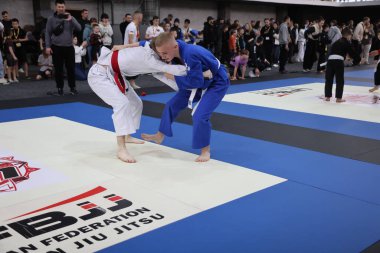 ODESSA, UKRAINE - 6 Nisan 2025: Ukrayna ulusal yarışmacı jiu jitsu genç sporcuları yoğun dövüşler düzenliyor, şampiyonluk için tatamiyle mücadele ediyorlar