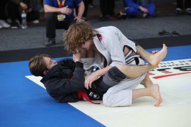 ODESSA, UKRAINE - 6 Nisan 2025: Ukrayna ulusal yarışmacı jiu jitsu genç sporcuları yoğun dövüşler düzenliyor, şampiyonluk için tatamiyle mücadele ediyorlar