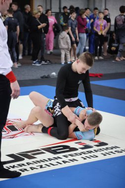 ODESSA, UKRAINE - 6 Nisan 2025: Ukrayna ulusal yarışmacı jiu jitsu genç sporcuları yoğun dövüşler düzenliyor, şampiyonluk için tatamiyle mücadele ediyorlar
