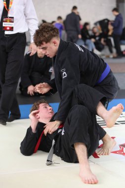 ODESSA, UKRAINE - 6 Nisan 2025: Ukrayna ulusal yarışmacı jiu jitsu genç sporcuları yoğun dövüşler düzenliyor, şampiyonluk için tatamiyle mücadele ediyorlar
