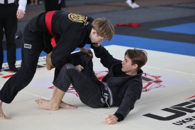 ODESSA, UKRAINE - 6 Nisan 2025: Ukrayna ulusal yarışmacı jiu jitsu genç sporcuları yoğun dövüşler düzenliyor, şampiyonluk için tatamiyle mücadele ediyorlar