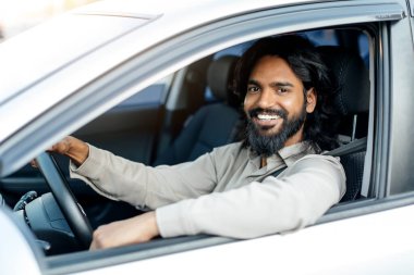 Kıvırcık saçlı genç bir ortadoğulu iki eliyle arka planda tutarak acı ya da rahatsızlık gösteriyor. İfadesi acı veriyor..