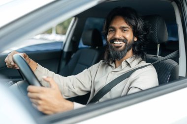 Neşeli Hintli adam araba kullanıyor, gösterge panelinden vurulmuş, yaz tatiline çıkıyor, fotokopi çekiyor. Yeni arabasıyla gezen, günlük kıyafetli ve gözlüklü mutlu bir orta doğulu.. 