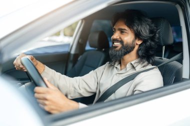 Kıvırcık saçlı genç bir ortadoğulu iki eliyle arka planda tutarak acı ya da rahatsızlık gösteriyor. İfadesi acı veriyor..