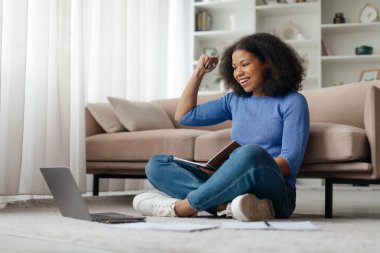 Heyecanlı Afrikalı Amerikalı kız öğrenci online başarı başarısını kutlarken coşkulu hissediyor, genç kadın iyi e-posta haberlerinden memnun, büyük bir teklifle veya yeni bir fırsatla motive oluyor.