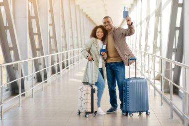 Tökezleyeceğiz. Pasaportları ve uçak biletleri ile gülümseyen mutlu Afrikalı çift. Yüksek kalite fotoğraf