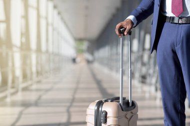 Cropped of businessman is walking with his luggage in a modern airport. The mood is dynamic and professional, highlighting travel and business with a sleek airport backdrop. High quality photo clipart