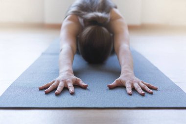 Yoga yapan bir kadın, çocuk egzersizi yapan bir kadın, Balasana pozu, boş alan olan bir panorama. Yüksek kalite fotoğraf