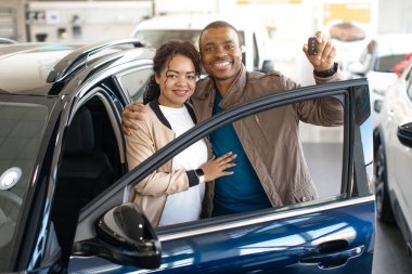 Yeni otomobil. Neşeli Eşler Satış Salonunda Yeni Araba Anahtarı Poz Veriyor ve Tutuyor. Yüksek kalite fotoğraf